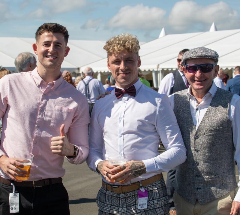Three male race goers posing for a picture at Ffos Las Racecourse