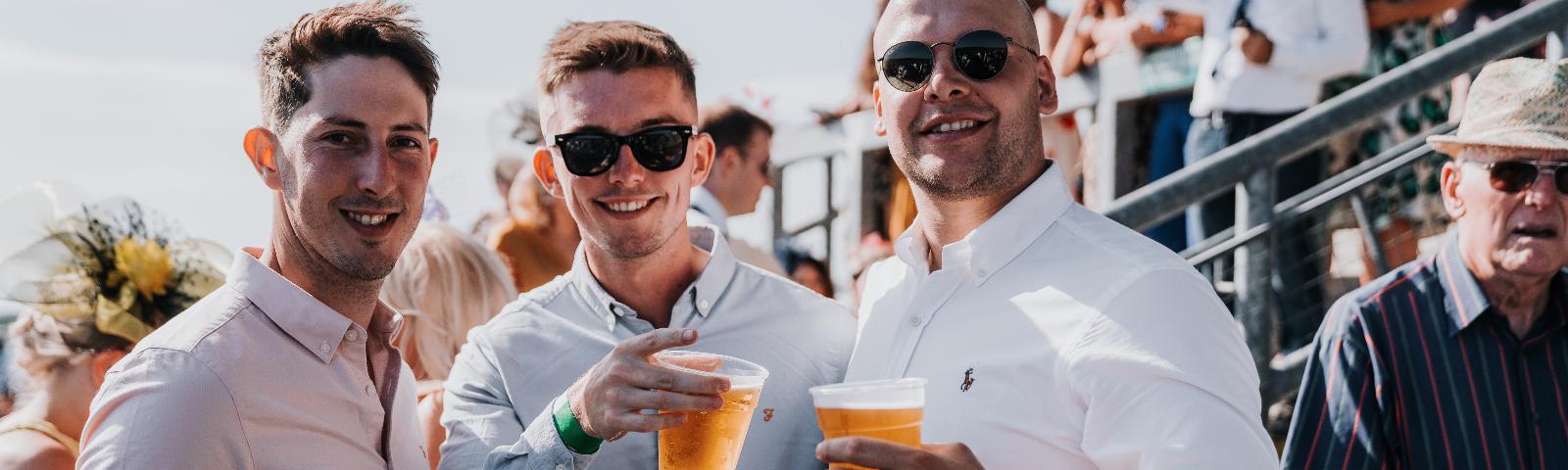 Three men in shirts smile for the camera