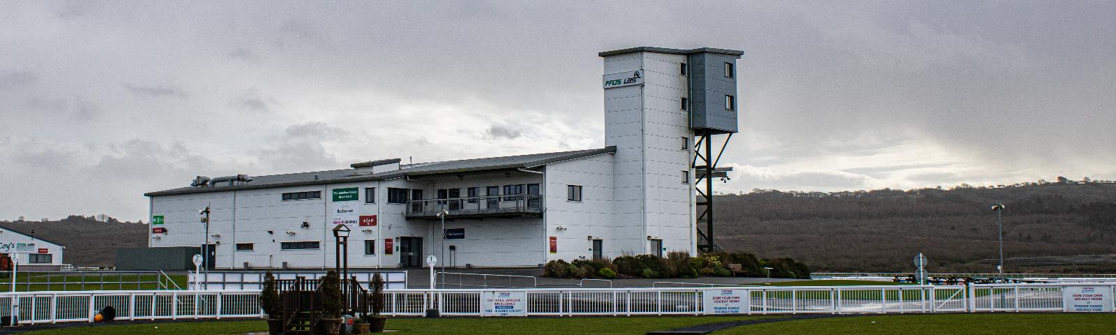 Main grandstand building at Ffos Las Racecourse with the parade ring in the foreground.