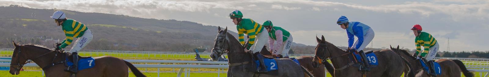 Horses running around the racetrack at Ffos Las