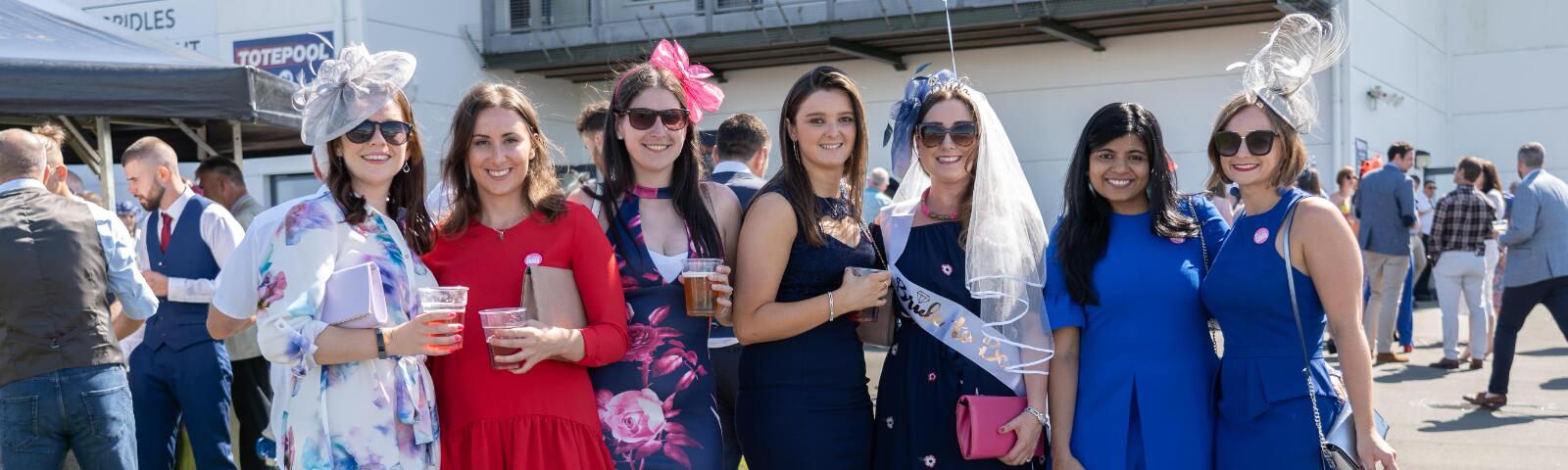 A hen party all dressed up for the races pose at Ffos Las Races